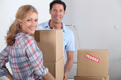 Professional movers handling packed boxes in a modern Canary Wharf building
